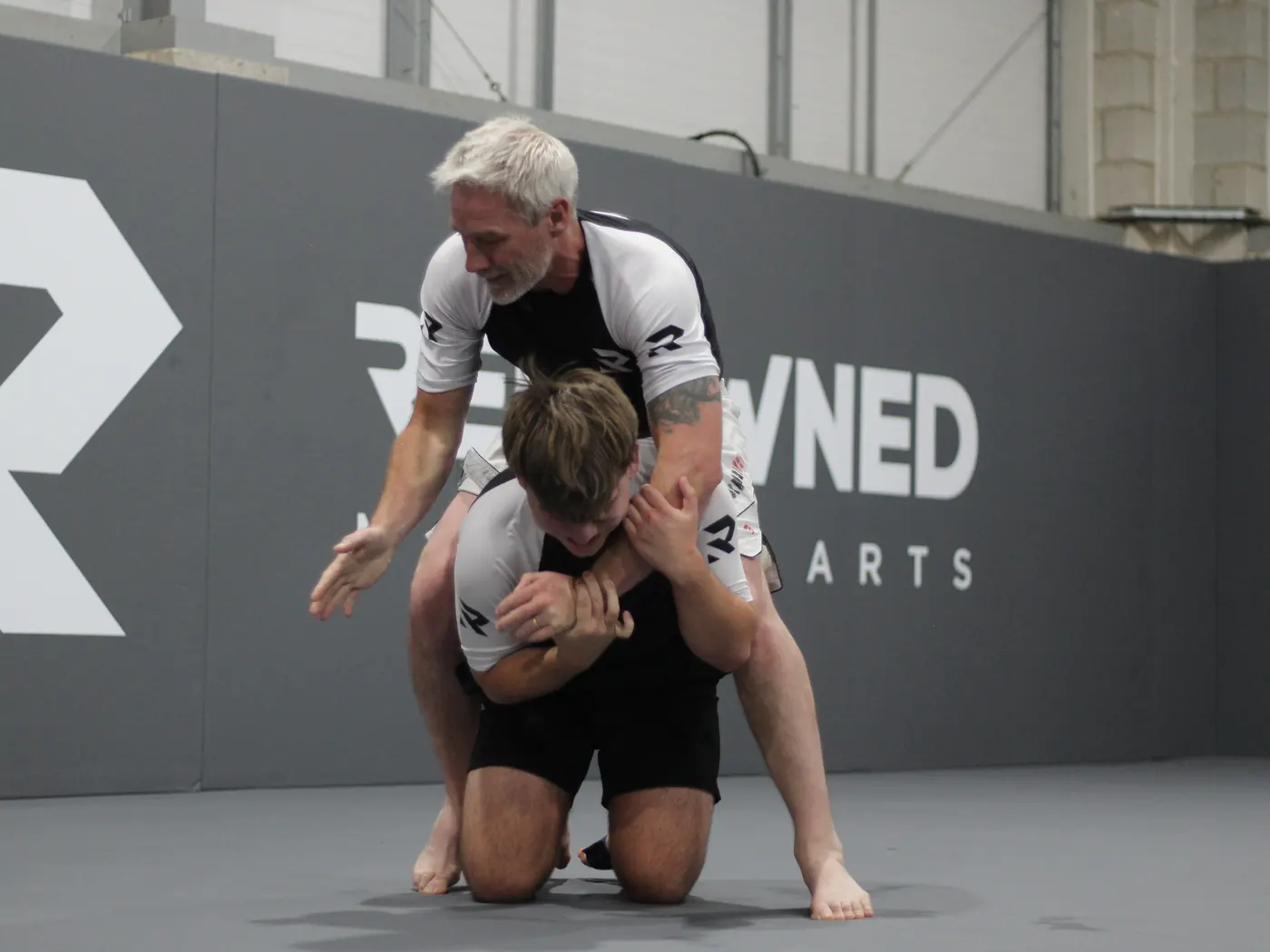 A coach working one to one with a student on the mats
